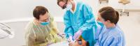 Faculty member demonstrates dental procedure to students.